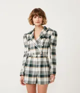 Blazer cropped con estampado de cuadros en tonos verde, blanco y marrón. Tiene cuello solapa, manga larga abullonada y cierre abotonado frontal.