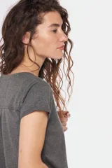 Remera color beige con cuello redondo, mangas cortas, bolsillo pequeño en el pecho y media botonadura frontal.