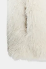 Chaleco de cuello subido y manga sisa, color beige, con efecto pelo. Incluye bolsillos laterales ocultos en la costura, forro interior combinado y cierre frontal con ganchos metálicos forrados.