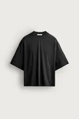 Camiseta relaxed fit de color negro con efecto lavado, cuello redondo y mangas cortas amplias.