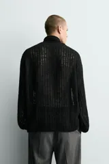Jersey de punto con estructura abierta y diseño de red, corte relajado, cuello redondo y manga larga.