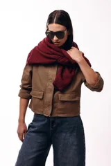 Campera corta color marrón, con cuello alto estructurado, cierre frontal y bolsillos delanteros con solapa. Presenta puños y cuello en tejido acanalado, con un diseño de corte recto y minimalista.