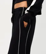 Pantalón de corte recto color negro con tiras laterales blancas en contraste. Cuenta con cintura elástica y cordón ajustable.