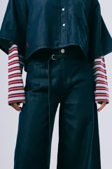 Pantalón wideleg de denim azul oscuro, de tiro alto y corte amplio con bolsillos laterales y cinturón incorporado.
