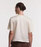 Blusa celeste de tejido satinado con cuello redondo, pliegues en el cuello y manga corta.