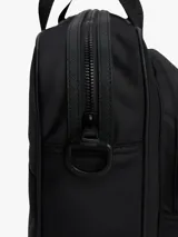 Maletín para portátil negro de poliéster, con acabado liso y logo metálico tonal de Tommy Hilfiger en el frente. Posee dos asas superiores y una correa ajustable extraíble para llevar al hombro. Incluye funda de portátil incorporada y múltiples bolsillos exteriores.