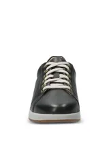 Championes Hush Puppies modelo Spinal Laceup de cuero color negro, con cordones grises, ojalillos metálicos dorados, entresuela gris y suela de goma.