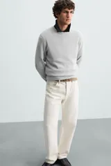 Sweater de punto color beige con textura tipo waffle, cuello redondo y mangas largas con acabado en rib.