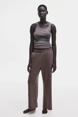 Pantalón deportivo de felpa liviana color marrón, de corte relajado y piernas rectas, con cintura elástica fruncida y bolsillos laterales.