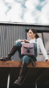 Mochila de diseño compacto con tapa frontal y cierre de hebilla tipo clip. Cuenta con correas ajustables, asa superior, bolsillos laterales y bolsillo trasero con cierre.