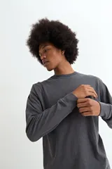 Remera de manga larga, color negro, con cuello redondo y corte recto.