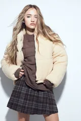Campera puffer de corderito color crema, con cuello alto y cierre frontal. Diseño oversized con textura teddy.