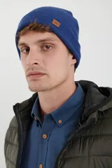 Gorro de lana azul con etiqueta de cuero con logo de la marca.