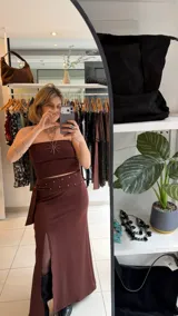 Falda midi color marrón, de tiro alto y confeccionada en lycra elastizada, con tajo frontal pronunciado.