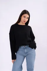 Sweater de punto grueso color negro, con cuello redondo, mangas largas y corte relajado.