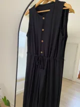 Mono largo color rojo, de morley, con corte holgado, sin mangas, con botones frontales y cinturón de lazo.