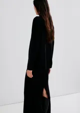 Chaleco negro de punto, de corte recto y largo, con cuello alto.
