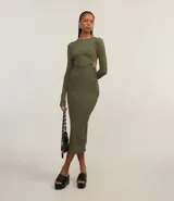 Vestido ajustado de largo midi, color verde militar, con cuello redondo y mangas largas. Presenta aberturas laterales en la cintura ajustadas con lazos.