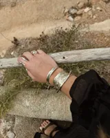 Anillo plateado con diseño abstracto y abierto, realizado en alpaca.