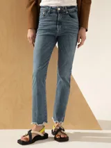 Jeans celeste de corte recto y tiro medio, con terminación desflecada.