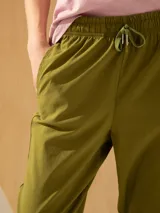 Pantalón babucha color verde oliva, tiro alto, largo arriba del tobillo, con cintura elástica ajustable con cordón y bolsillos laterales.