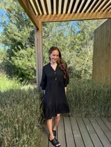 Vestido corto de lino color beige claro, con cuello mao, escote con botones de nácar, mangas tres cuartos con volados y ruedo con volado.