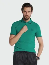 Remera polo de hombre, color verde esmeralda, de corte slim fit, con cuello y puños ribeteados en negro. Presenta un pequeño parche cuadrado con el logo de la marca en el pecho.