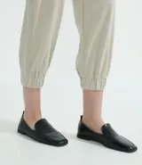 Pantalón estilo jogger de suedine, con cintura elástica y cordón ajustable, puños elásticos en los tobillos, bolsillos laterales y detalles perforados en los laterales y bolsillos.