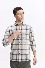 Camisa de manga larga confeccionada en viyela de algodón con diseño de cuadros en tonos azul y verde. Presenta cierre frontal con botones, cuello clásico y bolsillo en el pecho.