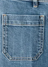 Jeans wide leg de tiro alto en tejido denim azul, con bolsillos de parche delanteros, trabillas para cinto y cierre frontal con cremallera y botón.