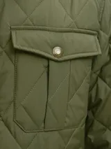 Campera acolchada de diseño matelaseado en color verde oliva, con cuello camisero en pana marrón, cierre frontal con botones a presión y bolsillos frontales con solapa.