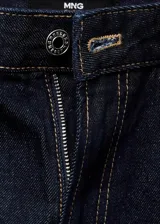 Jeans rectos de tiro medio color azul oscuro, con cinco bolsillos, trabillas para cinturón y cierre frontal con botón y cremallera.