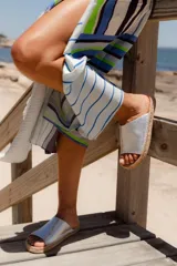 Sandalias tipo alpargata con capellada de cuero plateado y planta tejida en fibra natural de yute.