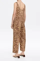 Mono de denim con estampado de leopardo, corte recto y largo hasta el tobillo. Presenta escote redondo pronunciado tanto en el frente como en la espalda, y tirantes anchos.