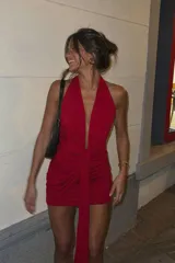 Vestido corto de color rojo, con escote halter pronunciado en V, tiras cruzadas para atar al frente y diseño drapeado ajustado.
