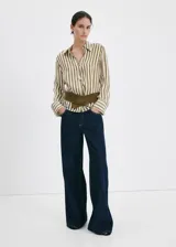 Camisa de lyocell semitransparente con estampado de rayas en tonos verde militar y blanco, cuello camisero, manga larga con puños abotonados y cierre frontal de botones.