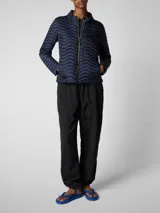 Campera acolchada ligera color azul marino, con diseño texturizado de ondas y cierre frontal de cremallera dorada. Tiene cuello alto y es de manga larga.