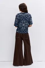 Remera de corte oversize color marrón con estampado tipo bandana en color blanco. Presenta cuello redondo y mangas cortas amplias.