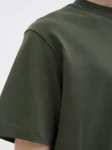 Remera verde militar de manga corta, con cuello redondo y diseño holgado. Cuenta con un pequeño estampado tipográfico en el pecho.