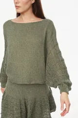 Sweater cropped de punto calado, color celeste melange, con mangas anchas de diseño holgado y cuello redondo.