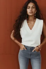 Jeans de tiro alto, color gris oscuro lavado, con corte ajustado en la parte superior y pierna acampanada (flare) desde la rodilla hasta el bajo. Presenta cinco bolsillos y cierre frontal con botón.