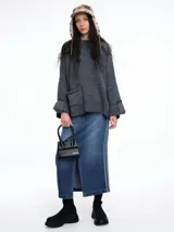 Sweater de tejido de punto color marrón con textura tipo waffle, diseño amplio, hombros caídos y cuello redondo. Presenta un bolsillo frontal aplicado y mangas con puños anchos decorados con botones.