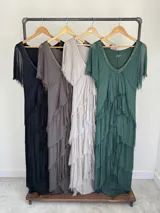Vestido largo de seda italiana color verde oscuro, con capas escalonadas con flecos, escote en V con detalle de paillettes y mangas cortas fluidas.