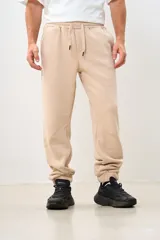 Pantalón de jogging color beige, con cintura elástica ajustable con cordón, bolsillos laterales y corte holgado.