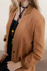 Tapado largo color blanco, de lino y algodón, con cuello en V abierto y sin cierre.