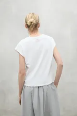 Camiseta blanca de manga corta con texto rojo "Because there is no planet B" en el frente.