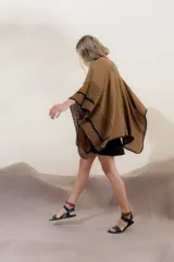 Ruana tejida en algodón color beige, con terminaciones de crochet color naranja. Diseño con mezcla de puntos y combinación de colores.