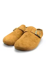 Zuecos de gamuza color amarillo, diseño cerrado en la parte delantera y destalonado, con una tira superior ajustable mediante hebilla metálica.