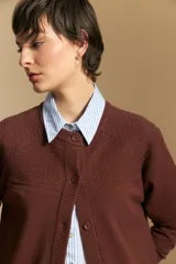 Cardigan de tejido de punto color rojo, con cuello redondo, cierre frontal de botones al tono y puños acanalados.