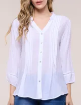Blusa de silueta suelta color azul, con escote en V y cuello mao. Cuenta con abotonadura frontal, alforzas verticales en el pecho y mangas tres cuartos con puños elastizados.